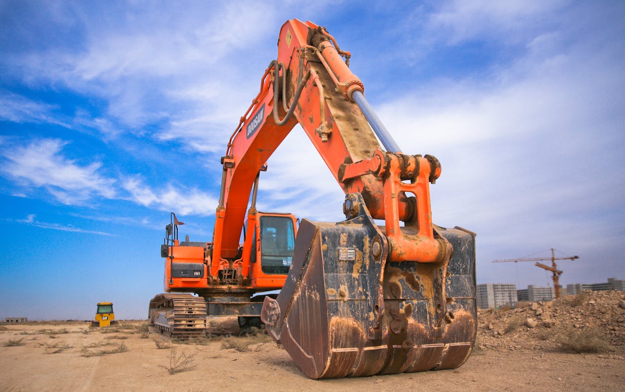 Mastering the First Impression: Your intriguing post title goes here A large orange excavator working on a construction site under a blue sky.