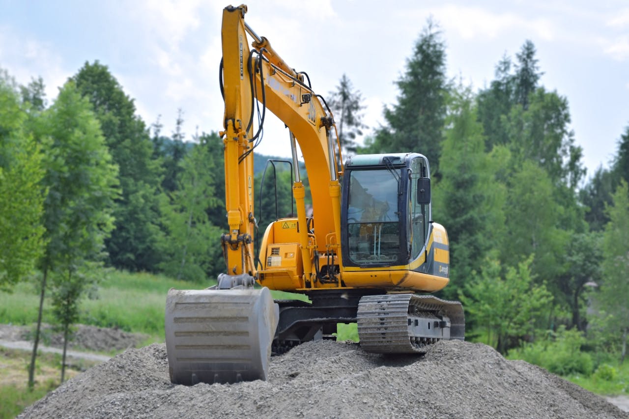 Crafting Captivating Headlines: Your awesome post title goes here A yellow excavator on a pile of gravel in a lush, green forest setting in Poland.
